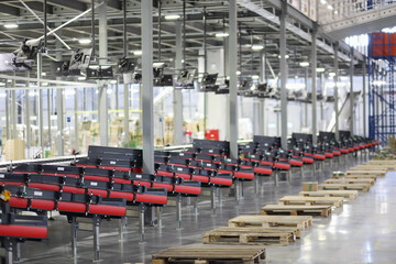 Big empty modern workshop with conveyors for sorting of goods, displays