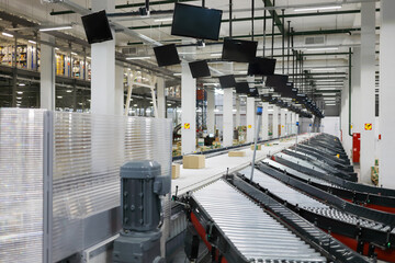 Empty modern workshop with conveyor, many displays in large warehouse