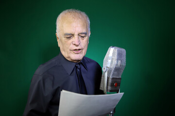 
Announcer speaking into microphone and reading the news. Mature journalist reporting the news on...