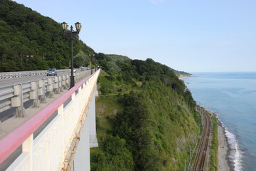 Cars on highway and railway, lanters, mountain and sea shore at summer day in Sochi, Russia