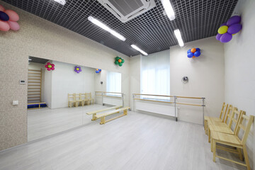 Empty lit gym with big mirror, chairs in kindergarten for children - obrazy, fototapety, plakaty