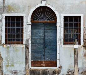 Arched doorway and windows with grilles on in Venice