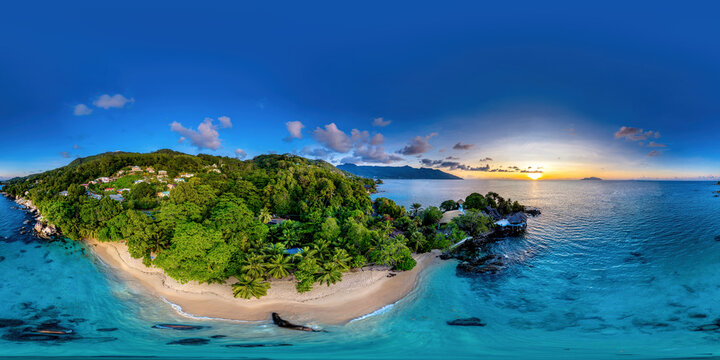 Amazing 360 drone panorama of a Sunset beach in Glacis, Mahe, Seychelles on a summer evening with a lush forest.