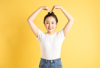 Portrait of Asian woman posing on yellow background