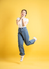 Full body image of an Asian woman dancing on a yellow background