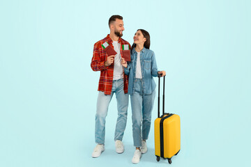 spouses pose with luggage and passports ready for trip, studio