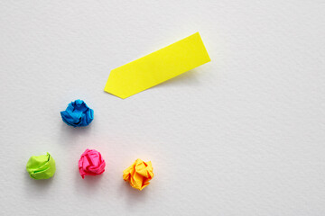 Yellow note next to other crumpled and discarded ones