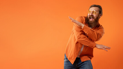 redhaired bearded guy in sunglasses dances with funny moves, studio