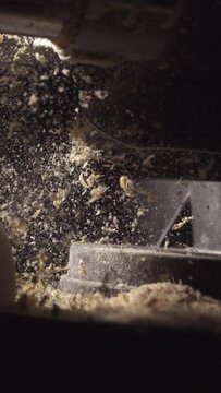 Experience the artistry of woodworking in stunning 4K vertical slow motion as a circular saw expertly carves through timber and wood chips and sawdust dance in the air.