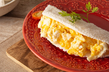 Tapioca Pancake with eggs Brazilian manioc food in top front view red plate