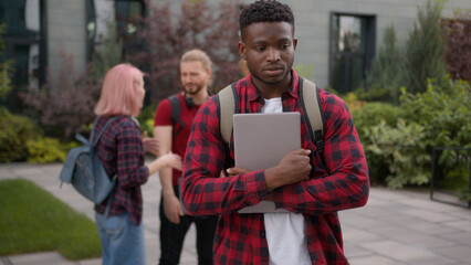 Group of angry students teenagers multiracial classmates laughing humiliate bully mockery at college university outdoors discriminate mock African American sad upset man student stressed guy problem