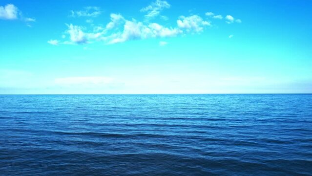 Ocean background and sea water and clear sky. For summer vacation ideas The nature of the beach and summer sea with the sun shining on the sea sparkling against the blue sky.