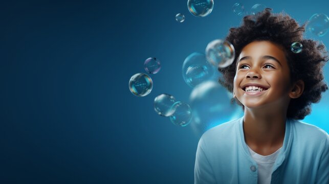Cheerful African little boy, on a blue background with flying soap bubbles, banner with empty space
