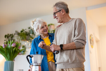 Senior couple preparing coffee at home
