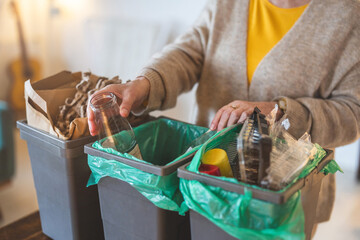 Senior woman sorting garbage in recycling bins at home
- 762350071