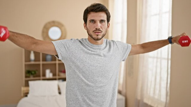 Man exercising with dumbbells in a bright home bedroom interior, depicting a healthy lifestyle and wellbeing.