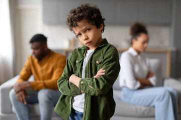 Child upset with parents arguing in background - obrazy, fototapety, plakaty