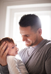 Fototapeta premium Father, baby and bonding with happiness and pride, growth and child development with love at family home. Man, infant or newborn with smile and dad holding kid for comfort, childhood and parenting