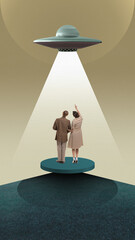 Couple looking at UFO with beam of light on circular platform, beige background. Contact with...
