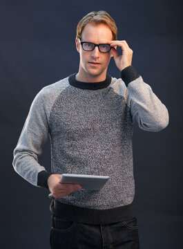 Man, glasses and tablet in studio portrait with connection, contact and fashion by dark background. Person, nerd or geek with digital touchscreen, pride and confidence with app for social network