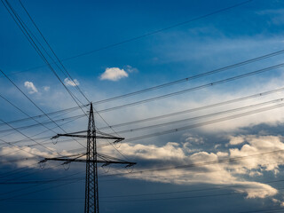 Strommasten und Leitungen am dunklen Wolkenhimmel