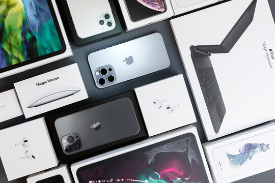 Surgut  Russia - March 19, 2024 : Flat lay of different generation of iPhone smartphone boxes: iPhones, headphones, mouse are on a grey background. The concept of the packaging of apple products.