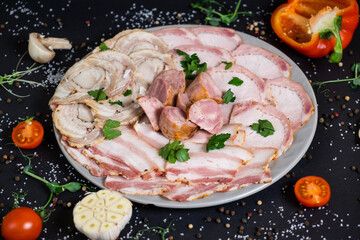Cured meat platter of traditional Spanish tapas. Chorizo, jamon serrano, lomo and fuet. Black background. Top view.