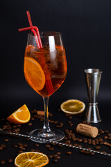 Elegant glass filled with fresh and tasty Aperol syringe summer cocktail on the bar counter on the black background
