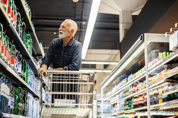 Elderly men doing shopping at market. Male consumer purchasing goods at grocery store, walking...