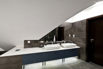 Interior of an elegant bathroom with grey theme tiles. Contemporary home interior design. 