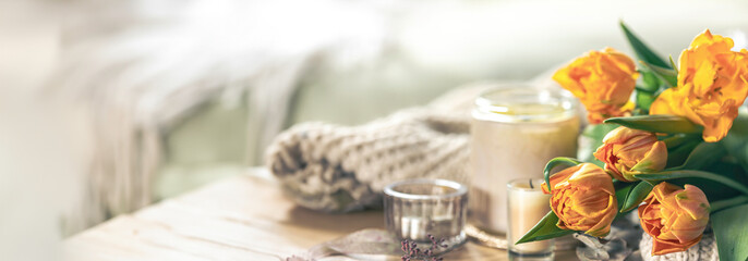 Spring background with tulips, candles and knitted element.