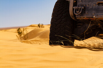 Background.  Close-up. The wheel of an all-terrain vehicle in the desert. © krysek