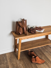 A leather tote bag, a cosmetic bag, sunglasses, suede Chelsea boots in the hallway interior