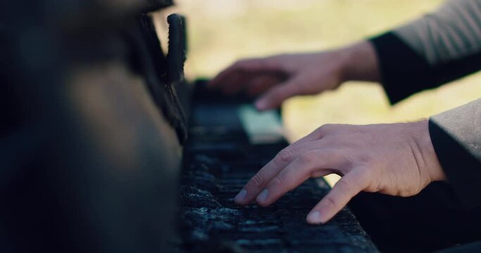 Man's hands play on burnt piano keys. A burnt piano. Man's hands on the piano.
