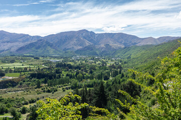 Obraz premium View from the Crown range looking over the Wakatipu Basin, a plain surrounded by mountains in the Queenstown Lakes District on the southern South Island of New Zealand.