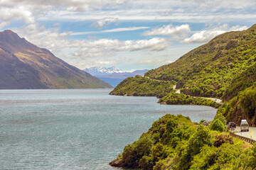 The scenic State Highway 6 meanders along a picturesque Lake Wakatipu towards Queenstown in southern New Zealand