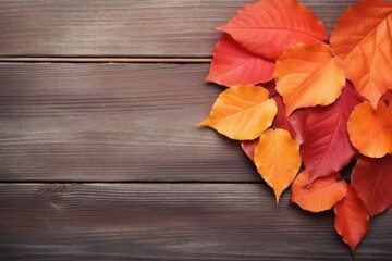 Naklejka na ściany i meble Vibrant autumn leaves spread over a rustic wooden background, depicting the essence of fall.