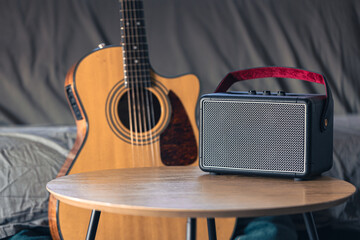 Close up, music speaker and acoustic guitar in the interior of the room.