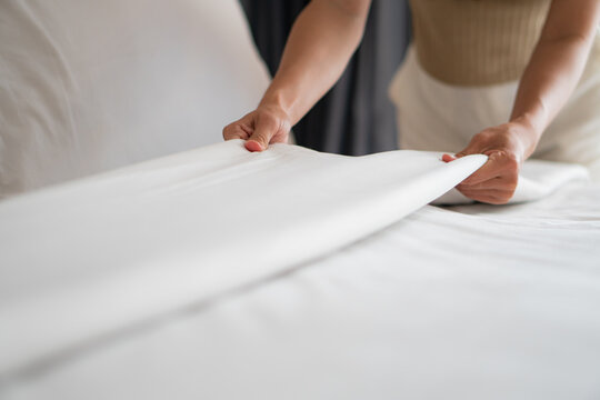 Housewife set up white sheet and cleaning in room. Housewife