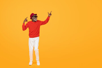 Stylish senior black man in a red sweater and hat, with sunglasses on