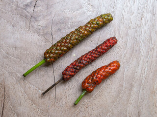 a bunch of Javanese chilies on a wooden base

