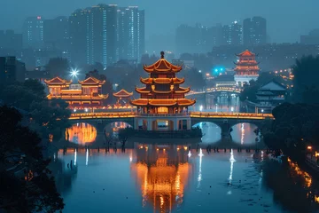 Papier Peint photo Pékin A bridge over a river with a lit up building in the background at night time with lights 