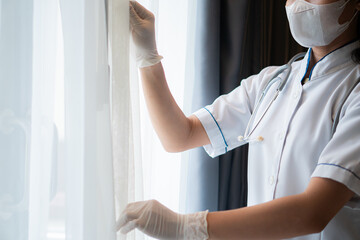 Nurse or medical staff open the curtains in the hospital room to allow light to reach the room...