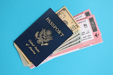 Blue United States of America passport with money and airline tickets on blue background close up. Tourism and travel concept