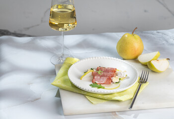 Fresh delicious salad with prosciutto, arugula with rose wine on light great marble background. Healthy diet concept. Italian cuisine. Vertical