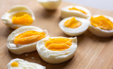Close-up of sliced boiled eggs arranged neatly on a wooden cutting board