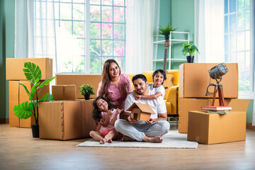 Happy Indian family unpacking boxes at new home