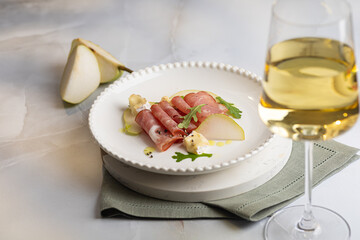 Fresh delicious salad with prosciutto, arugula with rose wine on light great marble background....