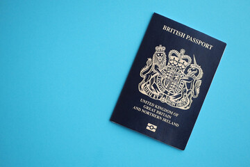 Blue British passport on blue background close up. Tourism and citizenship concept