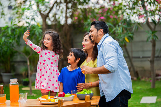 Indian couple and kids Enjoying Family Meal in the garden dining table